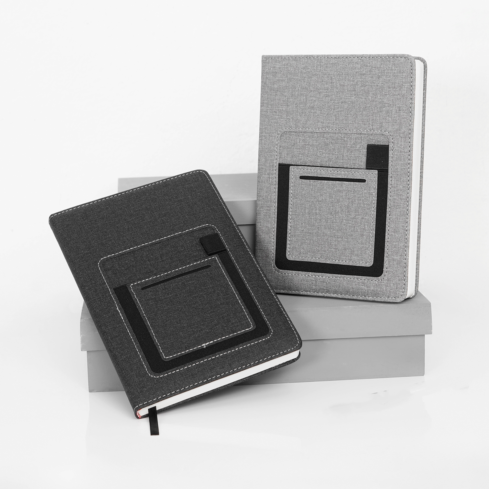 Libreta de poliuretano texturizada con compartimento para celular y resorte para pluma en la pasta, 112 hojas rayadas y separador. GRIS