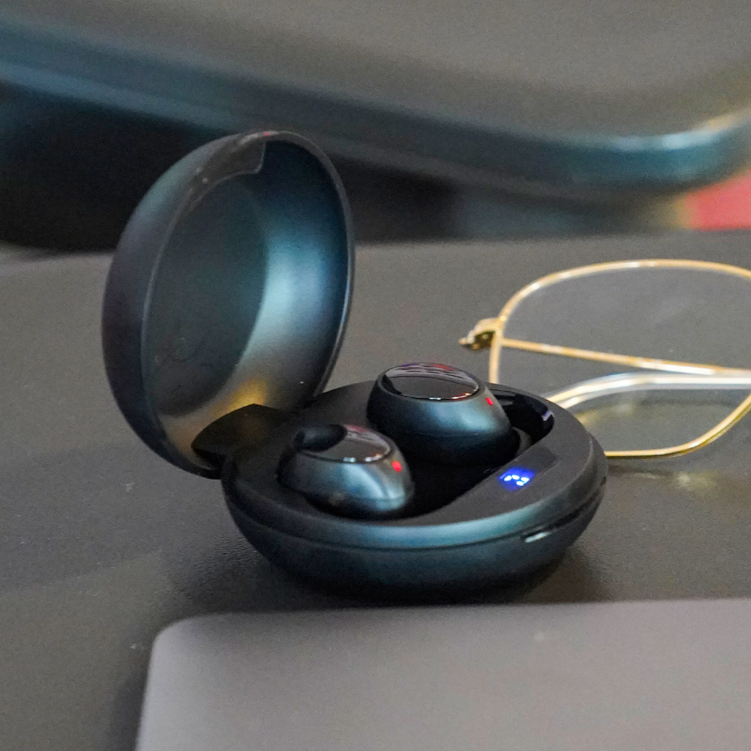 Audífonos bluetooth con estuche de plástico circular para carga y mecanismo touch. Incluye una pantalla de visualización de porcentaje de carga y cable. NEGRO